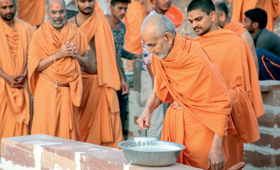 Swamis performing abhishek (milk offering)